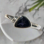 Silver ring with a purple stone on a white background