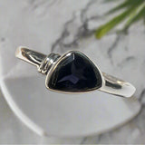 Silver ring with a purple stone on a white background