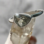 Silver pendant with a green amethyst gemstone on a light background