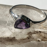 Silver ring with a purple gemstone on a textured surface