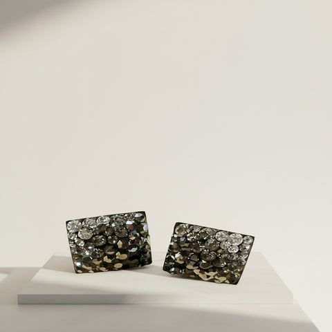 earrings on a walnut table in jungle
